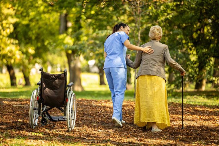 Older adult and family member reviewing home care and assisted living expenses at a kitchen table.